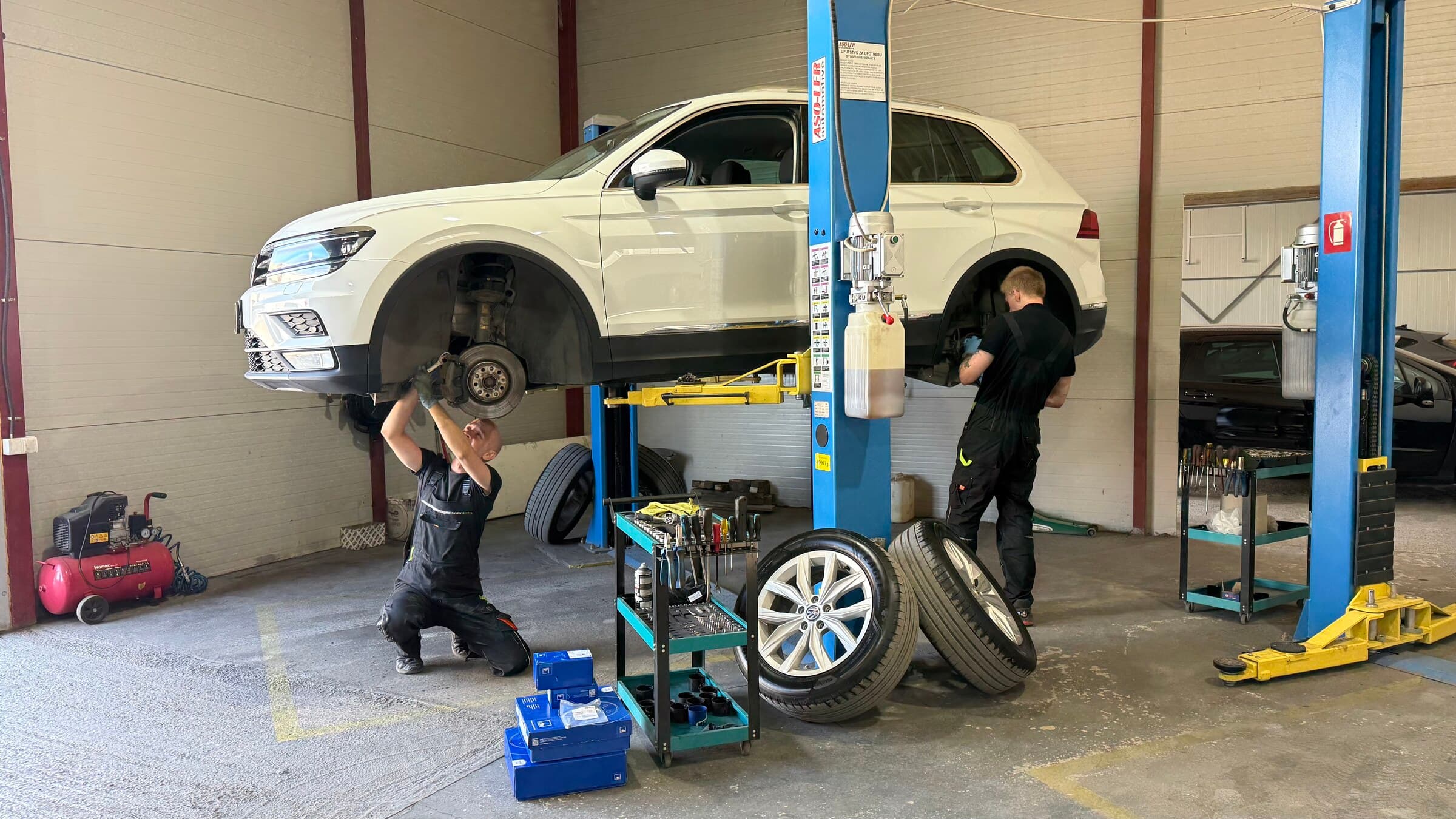 Автомобиль на подъёмнике со снятыми колёсами в цехе Just Service
